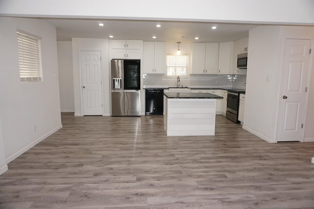 kitchen featuring a kitchen island, white cabinetry, sink, decorative backsplash, and stainless steel appliances