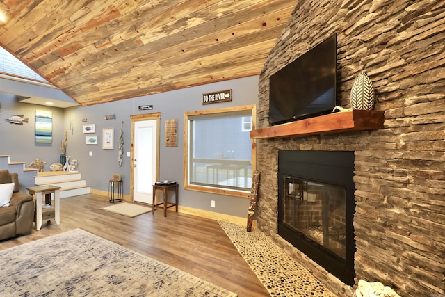 living room featuring wood ceiling, lofted ceiling, a stone fireplace, and hardwood / wood-style flooring