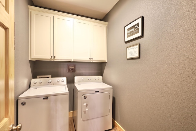 clothes washing area with washer and clothes dryer and cabinets