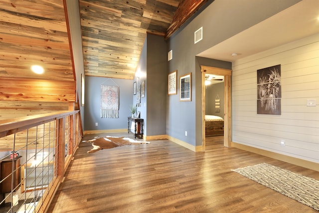 unfurnished room with lofted ceiling, hardwood / wood-style floors, wood ceiling, and wood walls