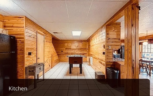 rec room with dark tile patterned flooring and wood walls