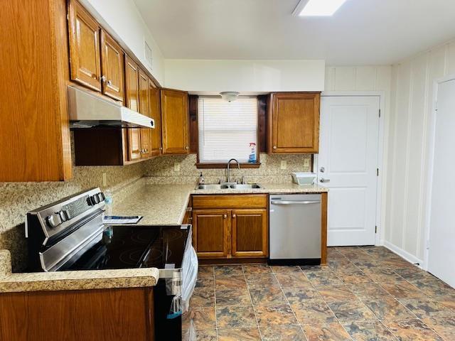 kitchen with tasteful backsplash, appliances with stainless steel finishes, and sink