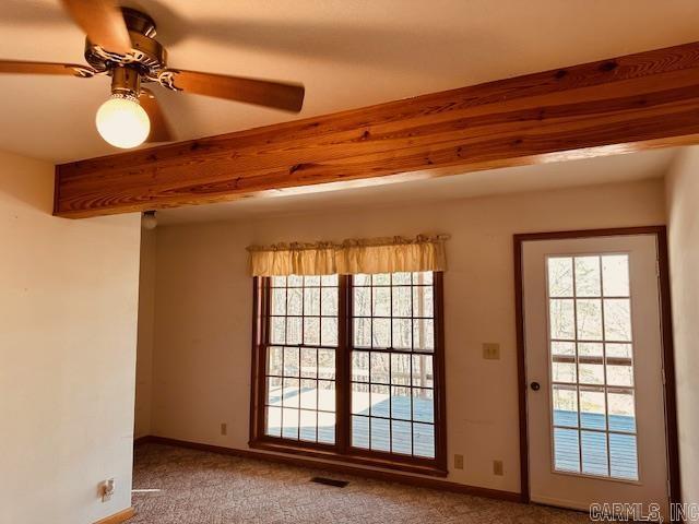 carpeted spare room with ceiling fan and beamed ceiling