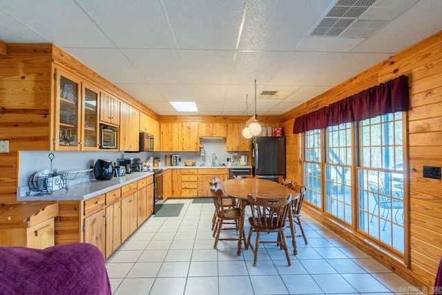 kitchen with light tile patterned flooring, appliances with stainless steel finishes, sink, and decorative light fixtures