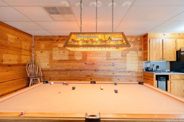 kitchen with wine cooler, billiards, wooden walls, and light brown cabinets