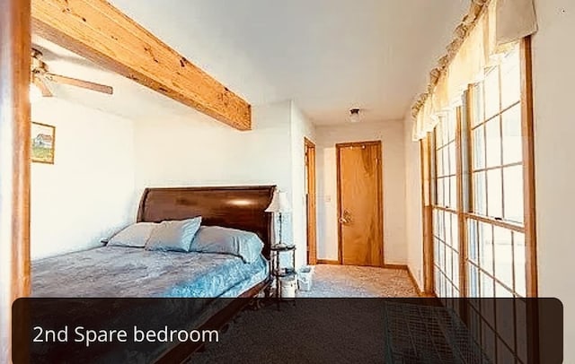 carpeted bedroom with beamed ceiling