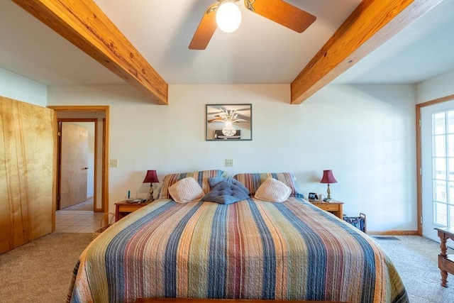 carpeted bedroom featuring beamed ceiling and ceiling fan