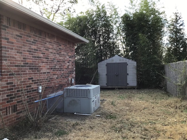 view of yard featuring central air condition unit and a storage unit