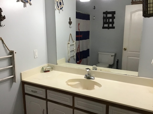 bathroom with vanity, a shower with shower curtain, and toilet