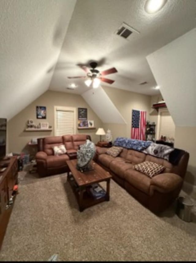 carpeted living area featuring visible vents, vaulted ceiling, and a textured ceiling