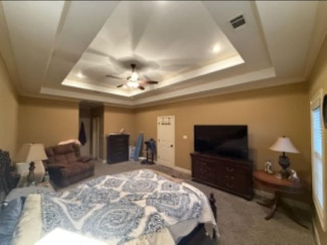 bedroom featuring a raised ceiling, visible vents, crown molding, and carpet flooring