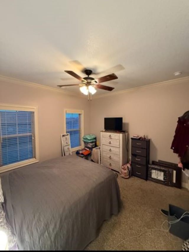 bedroom featuring carpet floors, ornamental molding, and a ceiling fan