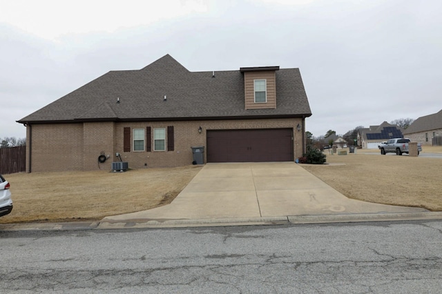 view of front of house featuring central air condition unit, a garage, brick siding, a shingled roof, and concrete driveway