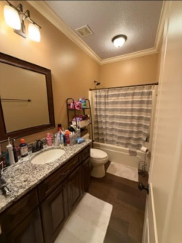 full bath featuring toilet, shower / bath combo, ornamental molding, and vanity