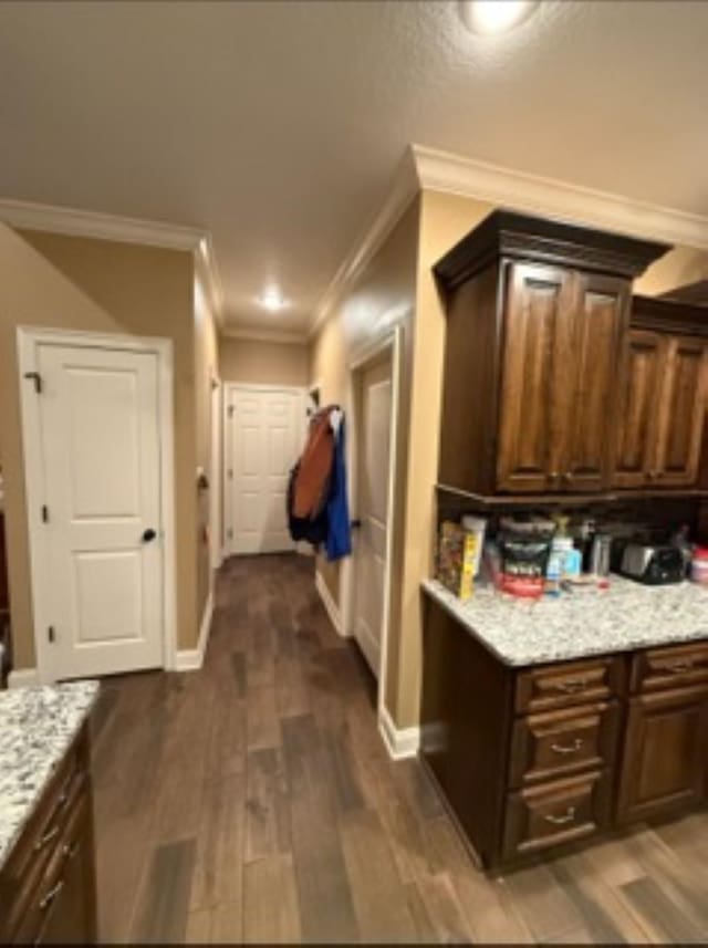 interior space with crown molding, dark wood-style flooring, and baseboards