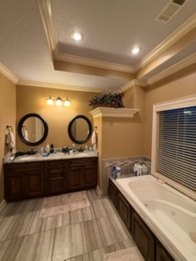 full bathroom with crown molding, double vanity, a raised ceiling, visible vents, and a jetted tub