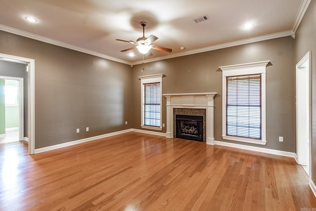 unfurnished living room with ceiling fan, ornamental molding, and light wood-type flooring