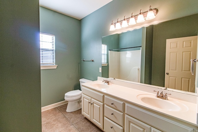 bathroom featuring tile patterned flooring, vanity, a shower, and toilet