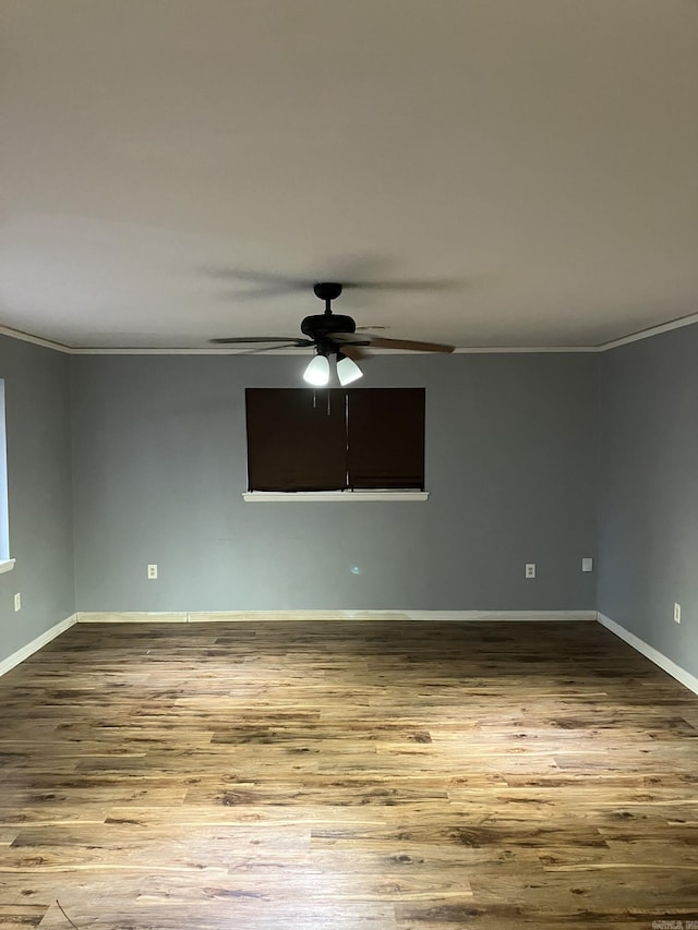 spare room featuring wood-type flooring, ornamental molding, and ceiling fan