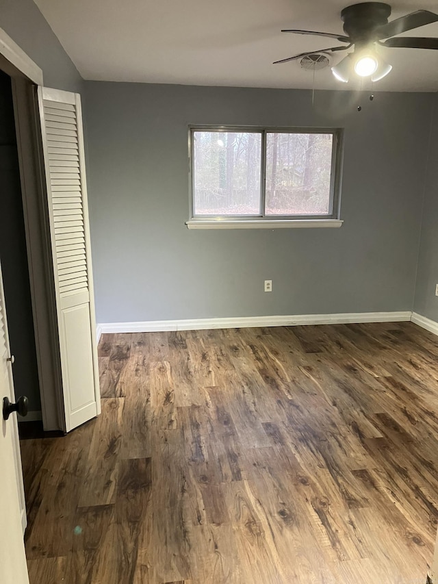 unfurnished bedroom featuring ceiling fan and dark hardwood / wood-style floors