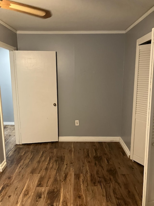 unfurnished bedroom with crown molding, dark hardwood / wood-style flooring, and a closet