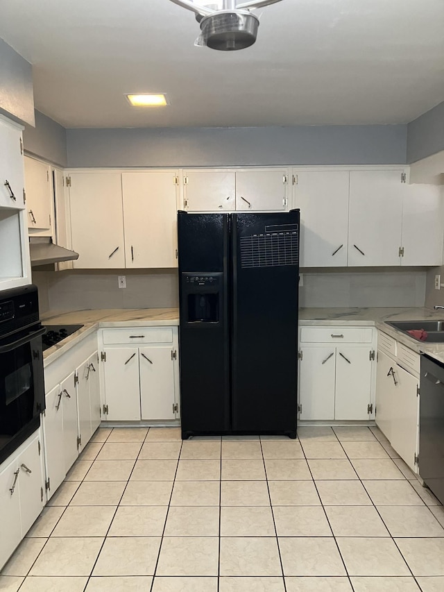 kitchen with sink, light tile patterned floors, white cabinets, and black appliances