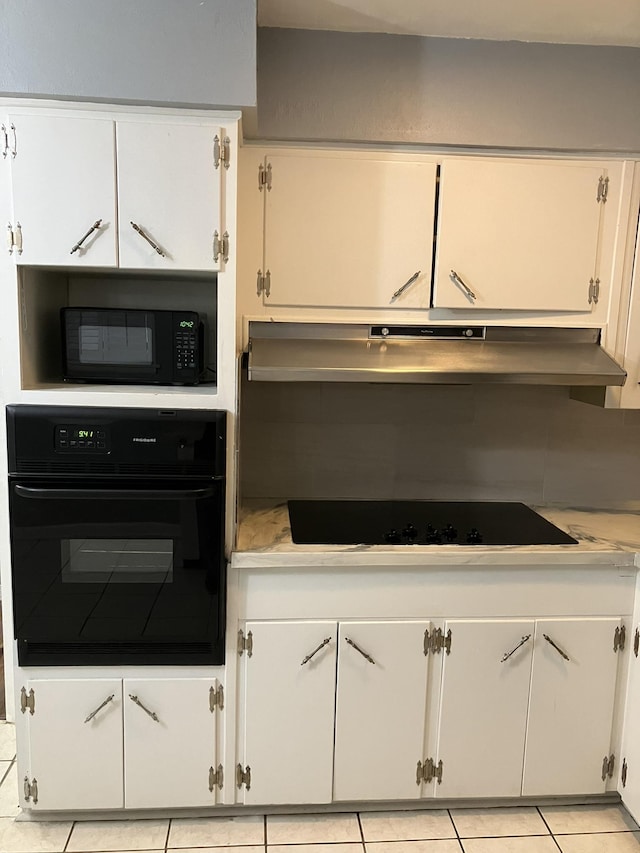 kitchen with white cabinetry, light tile patterned flooring, and black appliances