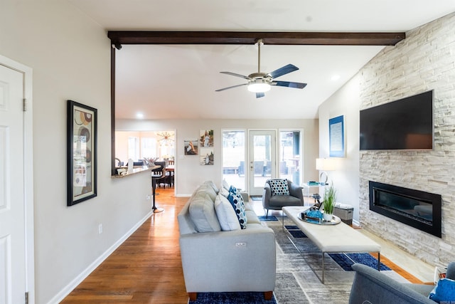 living room with a fireplace, dark hardwood / wood-style flooring, lofted ceiling with beams, and a wealth of natural light