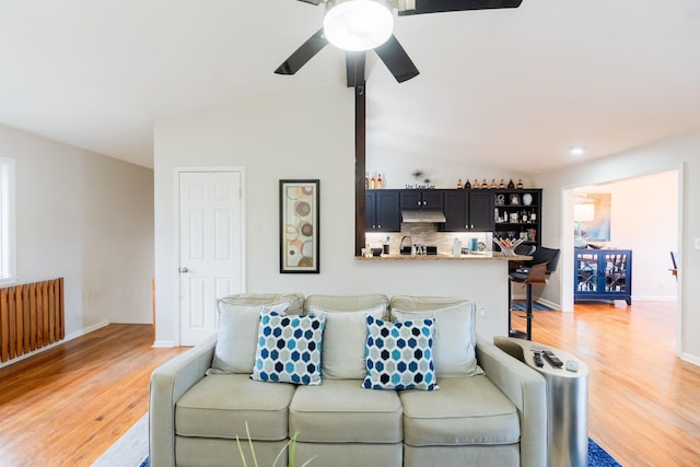 living room featuring lofted ceiling, light hardwood / wood-style floors, and ceiling fan