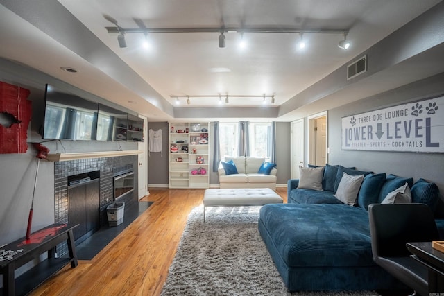 living room featuring hardwood / wood-style flooring, rail lighting, and a fireplace