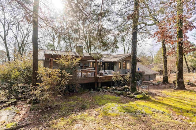 back of house with a wooden deck and a yard