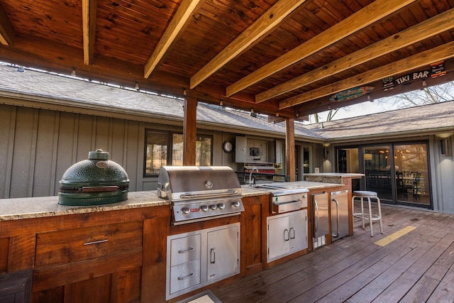 wooden deck featuring exterior kitchen and a grill