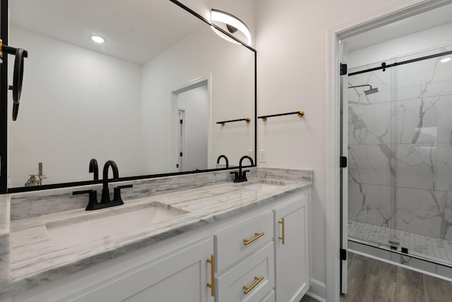 bathroom with hardwood / wood-style flooring, vanity, and a shower with door