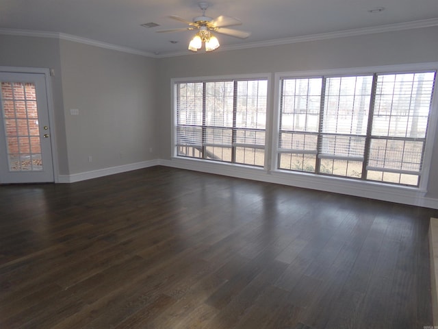 spare room with ornamental molding, plenty of natural light, and dark wood-type flooring