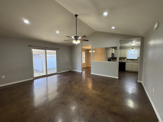 unfurnished living room with ceiling fan, sink, and vaulted ceiling