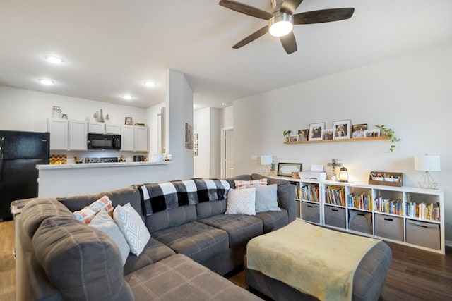 living room featuring dark wood-type flooring and ceiling fan