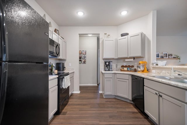 kitchen with dark hardwood / wood-style flooring, sink, and black appliances