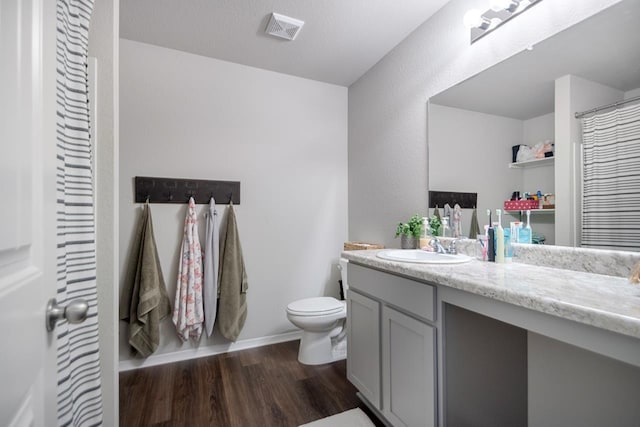 bathroom with vanity, toilet, and hardwood / wood-style floors