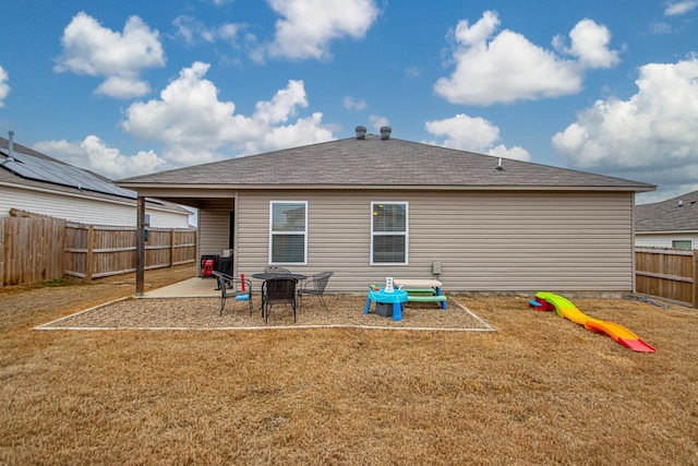 rear view of property featuring a playground, a lawn, and a patio area