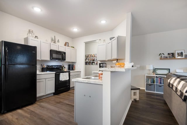 kitchen featuring white cabinetry, dark hardwood / wood-style floors, kitchen peninsula, and black appliances