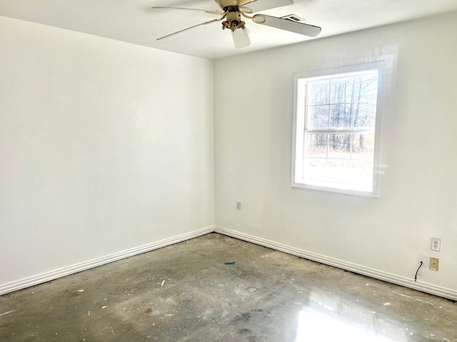 spare room with ceiling fan and concrete floors