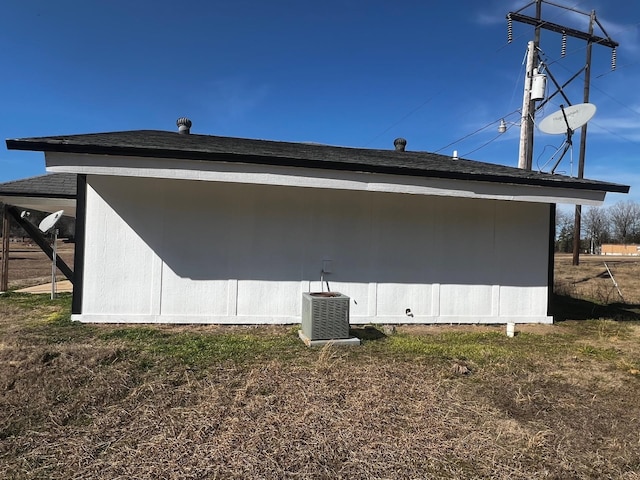 view of side of home featuring central AC and a lawn