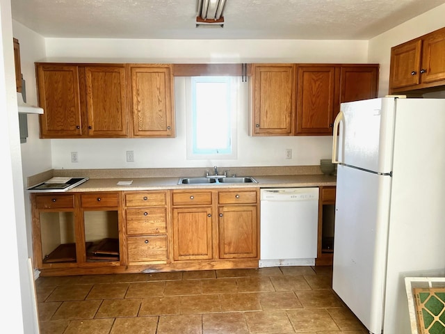 kitchen featuring white appliances, sink, and a textured ceiling