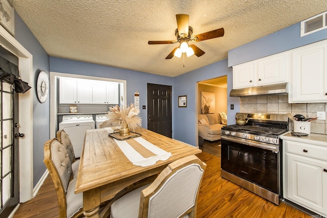 interior space featuring ceiling fan, washing machine and clothes dryer, dark hardwood / wood-style floors, and a textured ceiling