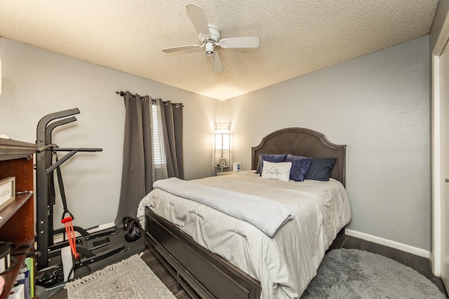 bedroom featuring ceiling fan, dark hardwood / wood-style flooring, and a textured ceiling