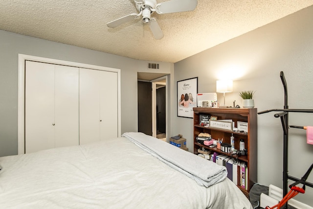 bedroom with ceiling fan, a textured ceiling, and a closet