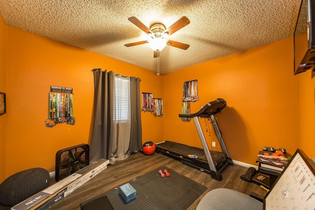 workout area featuring hardwood / wood-style flooring, ceiling fan, and a textured ceiling