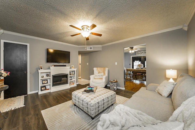 living room with ceiling fan, ornamental molding, dark hardwood / wood-style floors, and a textured ceiling