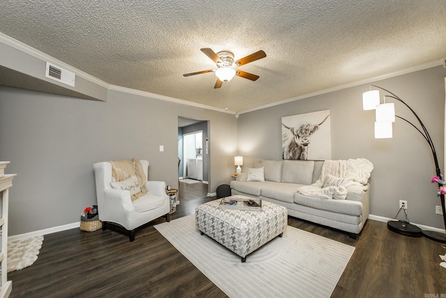 living room featuring dark wood-type flooring, ornamental molding, and a textured ceiling