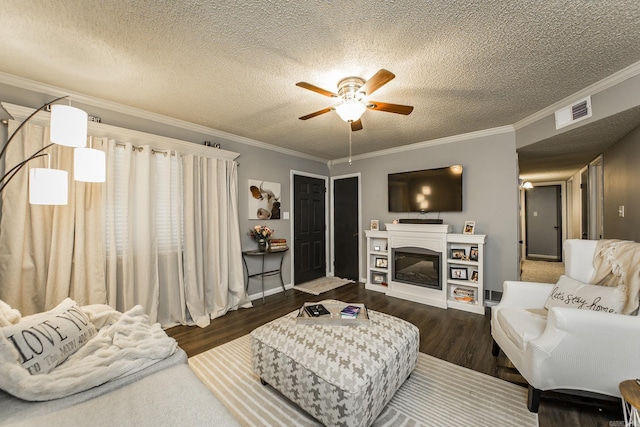 living room with dark hardwood / wood-style flooring, ceiling fan, ornamental molding, and a textured ceiling